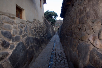 South America - Peru. Cobblestone street with drainage channel and Inca walls in the village of Ollantaytambo in Sacred Valley of the Incas.