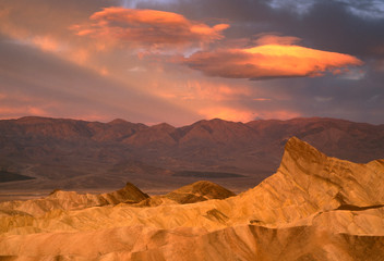 USA, California, Death Valley National Park. Dramatic morning sky lights Manly Beacon at Zabriskie Point against the Panamint Mountains.