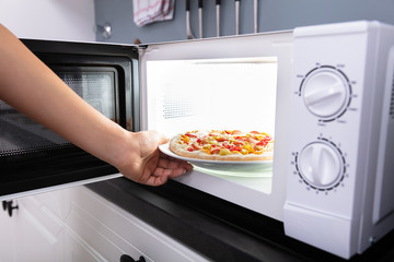 Woman Baking Pizza In Microwave Oven