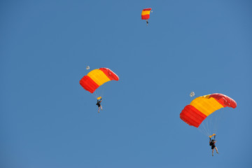 USA, Arizona, Eloy, people skydiving with orange and red parachutes