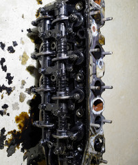 The head of the block of cylinders. The head of the block of cylinders removed from the engine for repair. Parts in engine oil. Car engine repair in the service