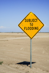 USA, California, Central Valley, San Joaquin River Valley, Angiola, Rt 43 sign 'Subject to Flooding' next to raised aqueduct