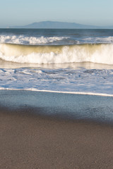 Usa, California, Oxnard. Offshore wind blows spray back from waves. Channel Islands on horizon
