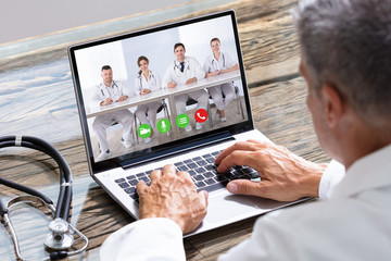 Doctor Having Video Conference On Laptop