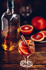Blood orange whiskey sour cocktail with aged bourbon, blood orange juice, cherry syrup and cinnamon