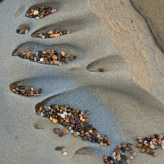 Usa, California. Colorful small pebbles deposited in abstract sculpted rock along the beach, Bean Hollow Beach, California, Usa