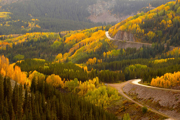A road meanders through the brilliant fall colors of the San Juan Mountains of Colorado