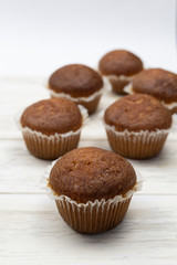 Homemade delicious chocolate muffins on wooden light table. Cupcake close-up. Homemade pastry rustic style. Minimalism.
