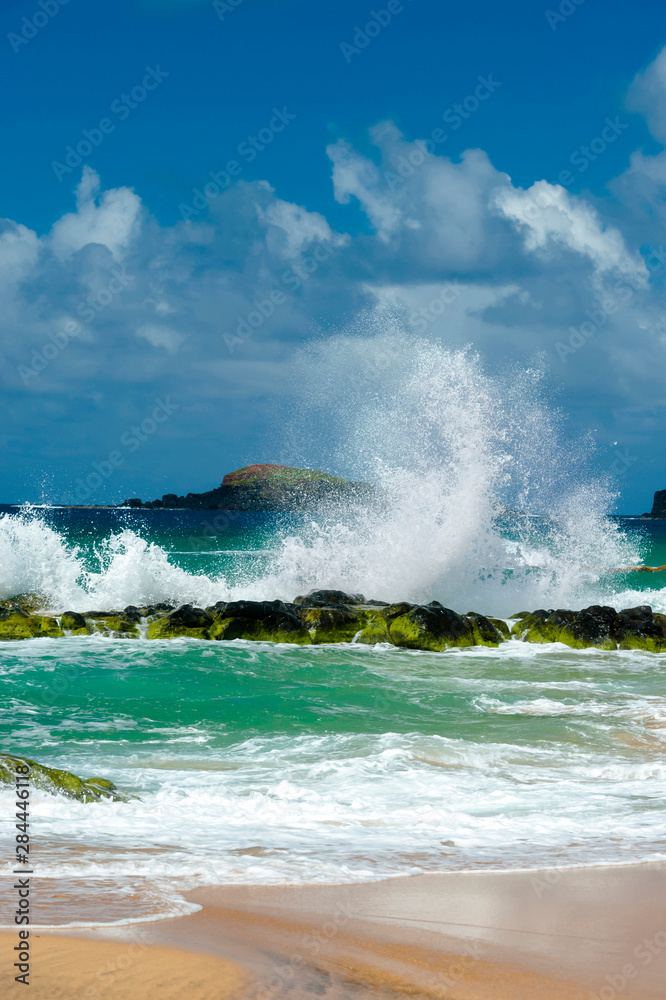 Sticker USA, Kauai, Hawaii. A wave breaks on the rocks at Kauapea Beach, popularly known as Secret Beach.