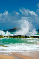 USA, Kauai, Hawaii. A wave breaks on the rocks at Kauapea Beach, popularly known as Secret Beach.