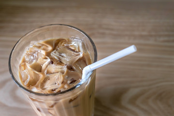 Iced coffee with straw on wood table