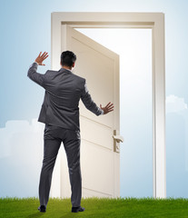 Businessman standing in front of door into future