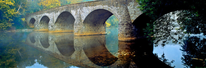 USA, Maryland, Hagerstown. Mist the lovely reflection of the stone curves of Wilson Bridge, at Hagerstown in Maryland.