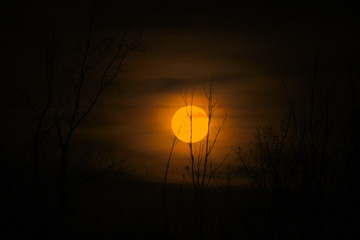 Dark silhoutte of the Supermoon in the night sky.