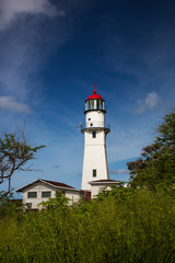 Fototapeta na wymiar USA, Hawaii, Oahu, Morning light on Diamond Head Lighthouse with Puffy Clouds