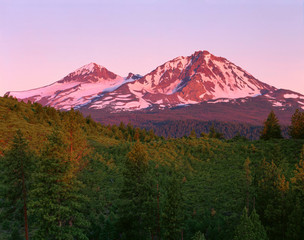 USA, Oregon, Deschutes National Forest. Sunrise reddens Middle Sister (left) and North Sister...
