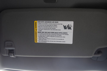 Air bag warning label on new vehicle visor warning of child placement