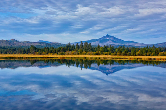 USA, Oregon. Clouds reflect in small lake at Black Butte Ranch. Credit as: Jean Carter / Jaynes Gallery / DanitaDelimont.com