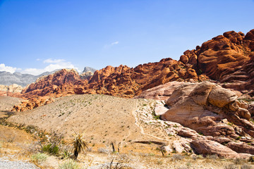Las Vegas, NV, USA - Desert landscape with rock formations and small mountains under a blue sky.