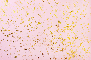 Golden sparkles on pink pastel trendy background.