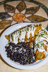 USA, Austin, Texas, Tex Mex cuisine. Pulled Pork Rellenos stuffed in Tecate, Spanish rice, red chili sauce, crema Mexicana, black beans. Texas Hill Country.