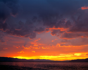 Fototapeta premium USA, Utah, Great Salt Lake. Storm clouds create a dramatic sky at sunset on the Great Salt Lake, Utah.