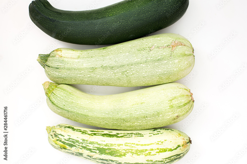 Poster Summer harvest of vegetables concept. Zucchini on a light white background.