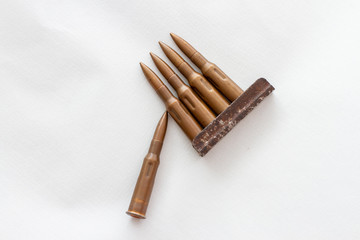 machine gun cartridges in a cartridge on a white background top view