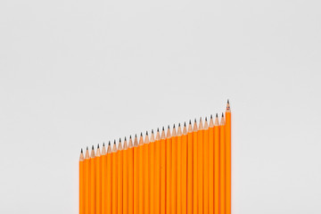 A bunch of pencils aligned in an ascending order on white background, shot from above.
