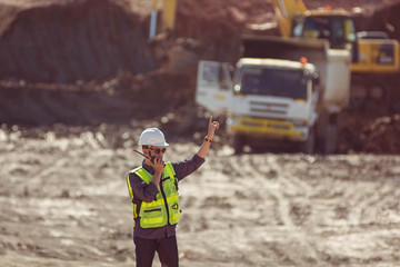 Portrait of asian male supervisor in mine soil field location operation a radio or walkie talkie