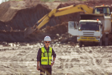 Portrait of asian male supervisor walking in mine soil field location