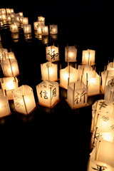 Seattle, WA, USA - Lit Asian paper lanterns in water at night for a festival.