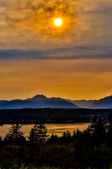 Bremerton, Washington State. The Brothers Mountain and the Olympic Mountains overlook Dyes Inlet, as the sun begins to set, casting a golden glow on the water