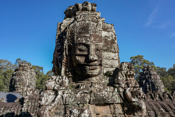 Detail Mural faces in the stone of Bayon belong angkor thom nearly angkor wat is popularity of the site among tourists with blue sky in background. UNESCO World Heritage Site. Siem Reap, Cambodia