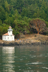 Fototapeta na wymiar USA, WA, San Juan Islands. Lime Kiln Lighthouse is an active navigational aid located in Lime Kiln Point Park. Favored spot for viewing Orcas in Haro Strait.