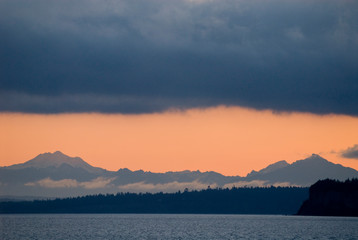 USA, WA, Puget Sound. Cascade Mountains predawn with dense deck of storm clouds above