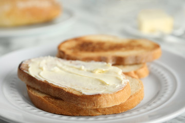 Tasty bread with butter on plate, closeup
