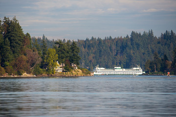 US, WA. Bremerton-Seattle ferry in Rich Passage framed by Point White on Bainbridge Island and...