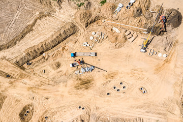 group of industrial machines installing water drainage system at construction site. drone image