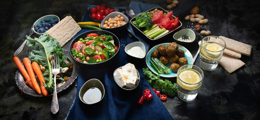 Vegetarian variety dishes on black background.