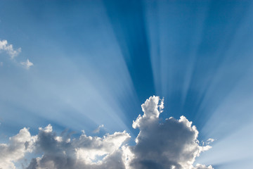 Crepuscular or God's rays streak past cloud. 