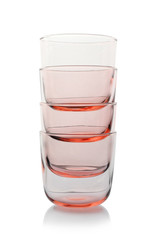 Stack of empty colorful whiskey glasses on white background