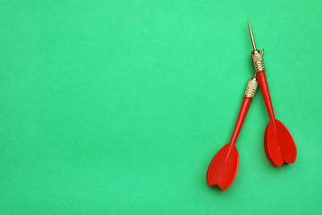 Red dart arrows on green background, flat lay with space for text