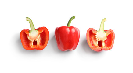 Cut and whole ripe red bell peppers on white background, top view