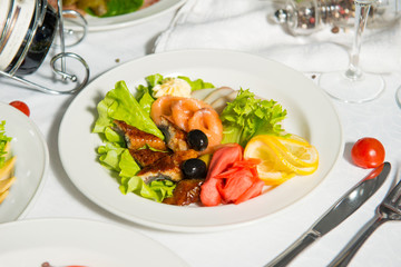 Fish appetizer in a plate in the interiors of a restaurant.Cold appetizer.