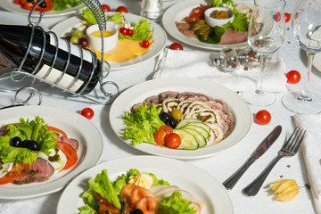 A restaurant dish of slicing meatloaf with vegetables on a table in a plate. Cold appetizer.