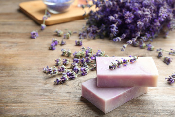 Obraz na płótnie Canvas Handmade soap bars with lavender flowers on brown wooden table. Space for text