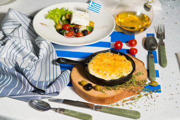 Julienne and greek salad on the table with flag of greece. Lunch at the restaurant.