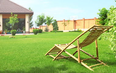 Wooden deck chair in beautiful garden on sunny day. Space for text