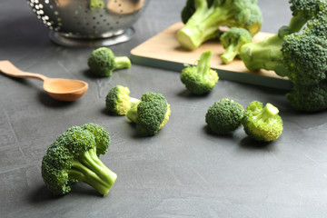 Fresh green broccoli florets on grey table